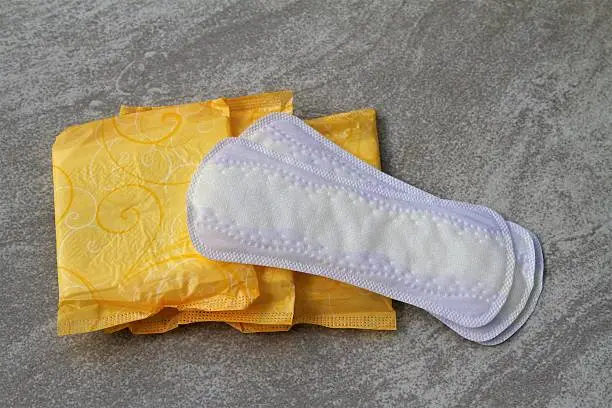 Women's personal hygiene items: pads and liners. Menstruation supplies and products on a gray tile background.  Creative content brief 683313911.