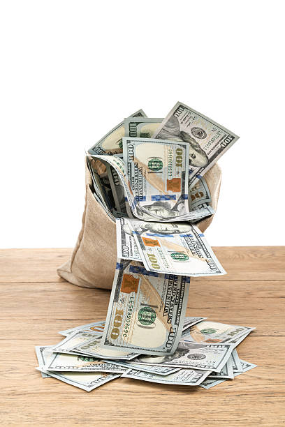 istock Dollars fall out of bag on table 628167188