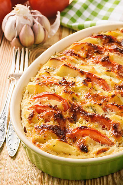istock Potato casserole with tomatoes, garlic and cheese. 628167230