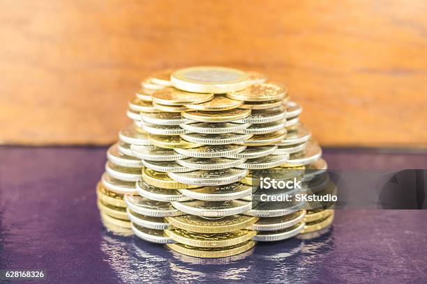 The Pyramids Of Gold And Silver Coins On Brown Blurred Stock Photo - Download Image Now