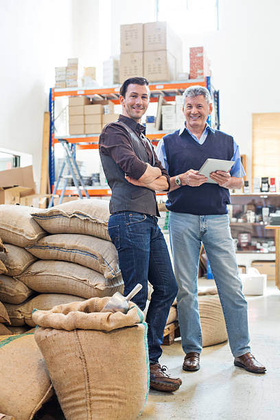 glückliche geschäftspartner im kaffeelager - coffee sack bag warehouse stock-fotos und bilder