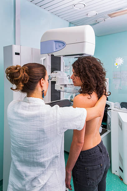 Nurse with young women having a mammography Nurse with young women having a mammography medical x ray stock pictures, royalty-free photos & images