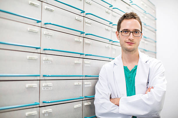 istock Confident pharmacist standing by a medicine shelf 628195224