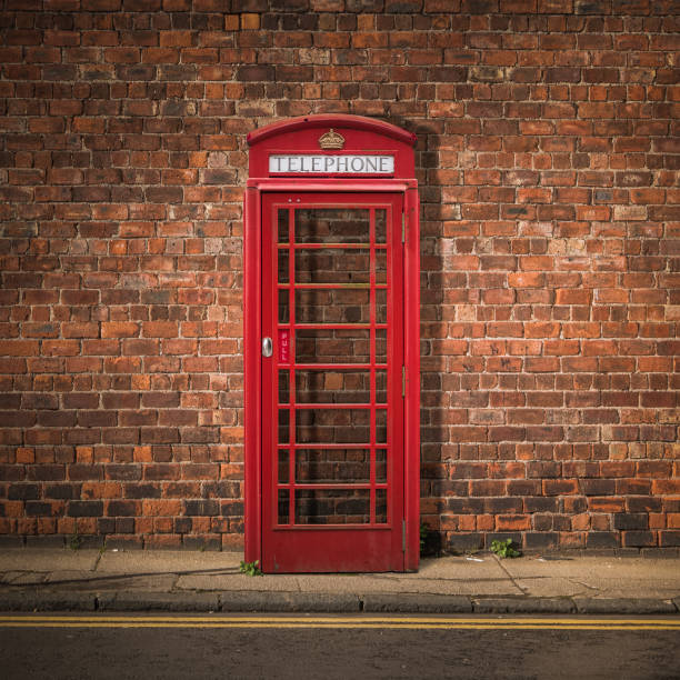 boîte téléphonique britannique contre mur de briques rouges - pay phone brick wall telephone old photos et images de collection