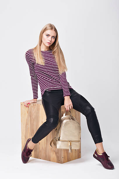 istock Pretty young girl in sweater striped posing in the studio 628208458