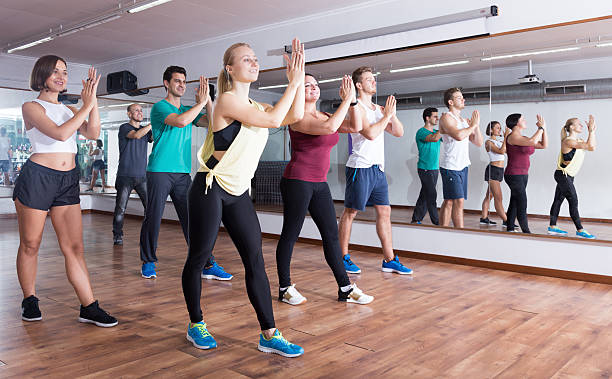 Young cheerful people dancing zumba elements Young cheerful people dancing zumba elements in dancing class curtseying stock pictures, royalty-free photos & images