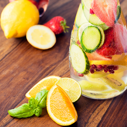 Infused water for detoxing your body with cucumber, strawberries, basil, lime, pomegranate seeds, oranges and lemons