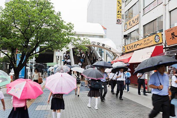 people walking through pedestrian walkway on a rainy morning - umbrella parasol rain rush hour imagens e fotografias de stock