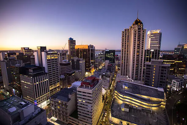 High angle shot of Auckland City Centre, as lights come on in the evening.