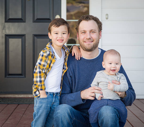 istock Mixed Race Father and His Two Sons on Front Porch 628216448