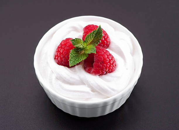 istock whipped cream bowl with raspberries close-up on gray background 628217664