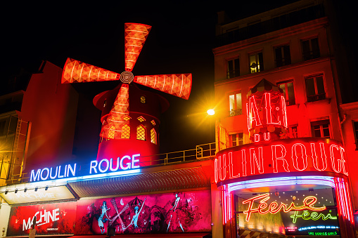 Paris, France - October 20, 2016: Moulin Rouge at night. It is a world famous cabaret in Paris. Today its a tourist attraction, offering musical dance entertainment for visitors from around the world