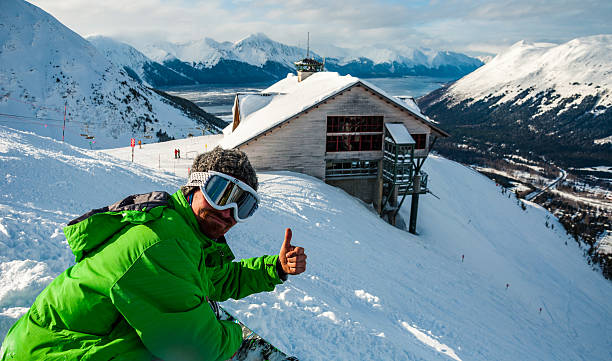 Snowboard Gives Thumbs Up For Good Snow Conditions Anchorage , Alaska , USA - February 25th, 2013: Snowboard Gives Thumbs Up For Good Snow Conditions at Alyeska Ski Resort With amazing winter landscape background thumbs up for skiing stock pictures, royalty-free photos & images