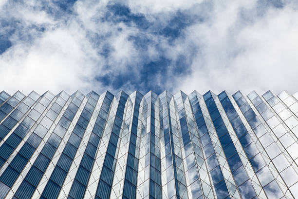A view looking up at the window encased side of the cube shaped federal courthouse building at North Broadway and 1st Street in the downtown Los Angeles Civic Center, with dramatic clouds overhead and reflecting across the facade.