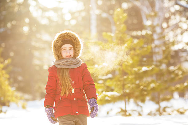 istock Little girl in red jacket walks in winter (sunshine) 628221210