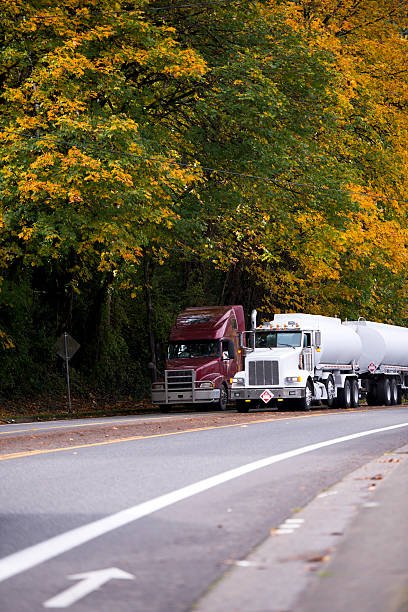 istock Two big rigs semi trucks with trailers on autumn road 628233038