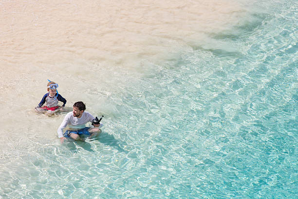 family of two enjoying snorkeling at caribbean vacation, active and healthy lifestyle