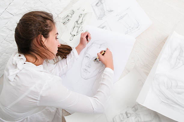 istock Woman drawing pencil portrait on floor in workshop 628233638