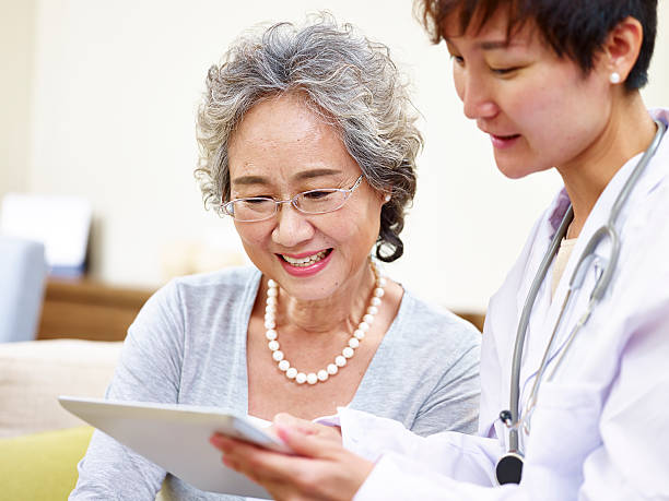 femme asiatique âgée consultante médecin de famille - culture coréenne photos et images de collection