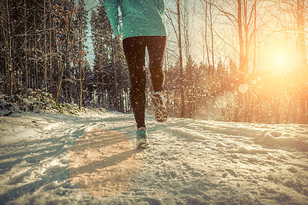 istock Woman Running at snowly winter under sunlight. 628250092