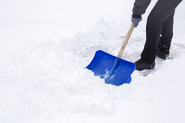 uomo che pulisce la neve con pala nella giornata invernale. - snow cleaning foto e immagini stock