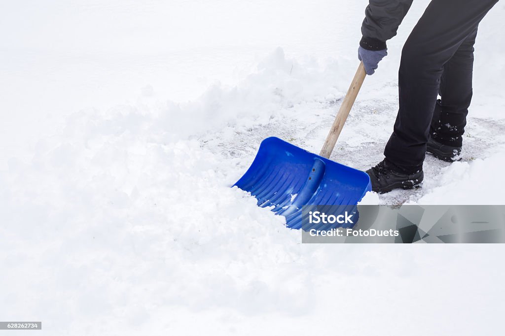 Man cleaning snow with shovel in winter day. Snow Stock Photo