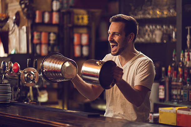 istock Playful bartender having fun with ice buckets at bar counter. 628263726