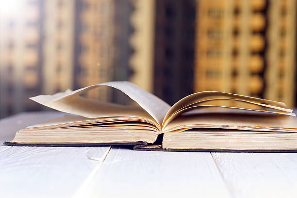 istock Open book on wood planks over abstract light background. 628264122