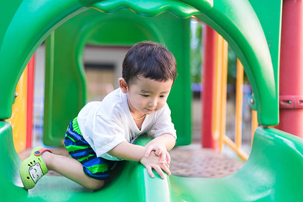 istock Little Asian kid playing slide at the playground 628276936