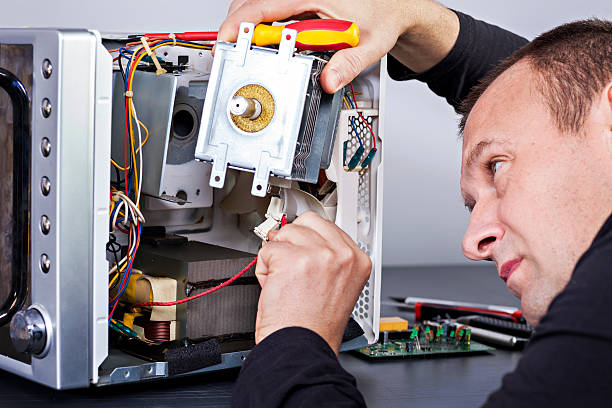 istock Serviceman electrician repairs a magnetron in the microwave 628277062