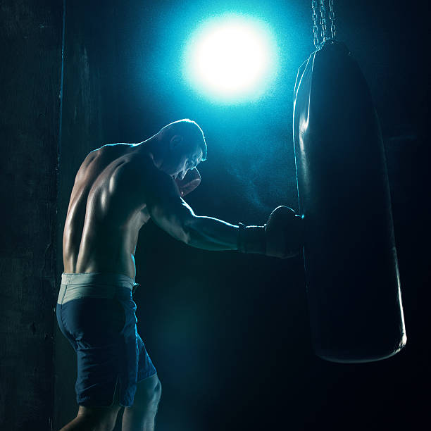 istock Male boxer boxing in punching bag 628277148