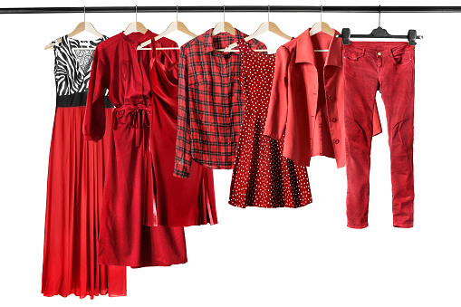 Group of red clothes on clothes racks isolated over white
