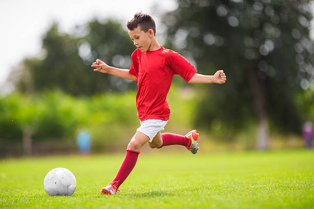 boy tiro a portería - soccer kicking ball the fotografías e imágenes de stock