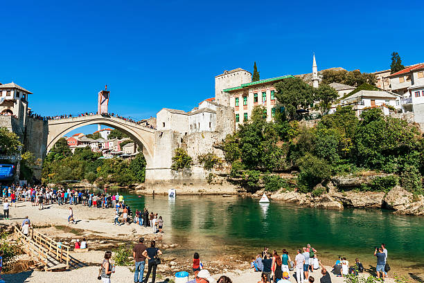 View of Mostar old town from a beach Mostar, Bosnia and Herzegovina - September 23, 2016: View of Stari Most bridge and Mostar old town from a beach where people come to view the famous red bull divers stari most mostar stock pictures, royalty-free photos & images