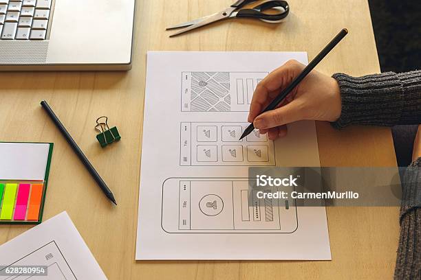 Designer Wireframing A Mobile App Stock Photo - Download Image Now - User Experience, Merchandise, Plan - Document