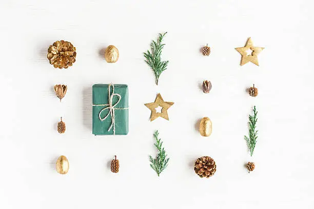 Photo of Gift, christmas decoration, cypress branches, pine cones. Flat lay