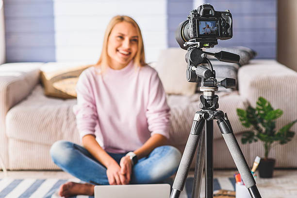 istock Cheerful young woman blogging at home 628289252