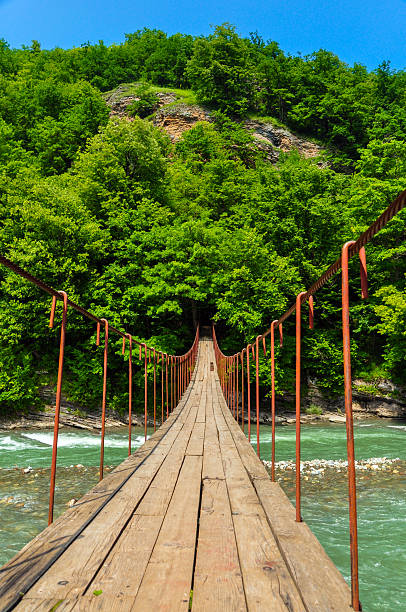 istock Suspension bridge over the stormy mountain river 628294940