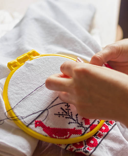 istock embroidery thread Cross Hands on a woman embroidering. Close-up 628296374