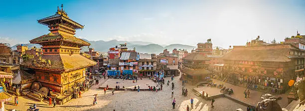 Warm sunset light filling the busy cobblestones of Taumadhi Square, overlooked by the ancient temples of Bhaktapur, the UNESCO World Heritage Site in Kathmandu, Nepal.