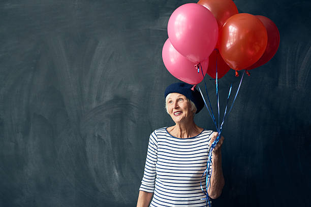 istock Dreamy elderly woman with balloons 628304628