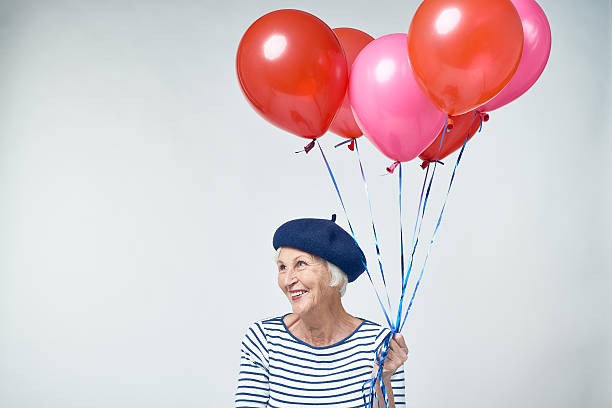 istock Senior woman with balloons looking away 628304744