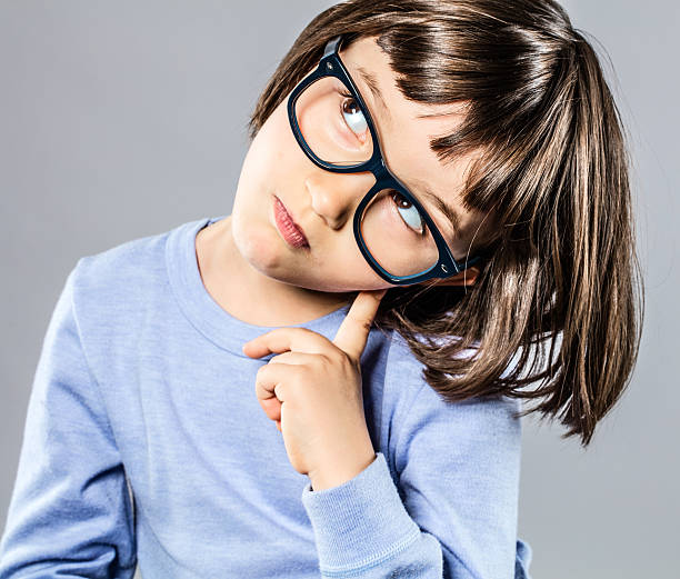 istock smart young child with serious eyeglasses holding head for intelligence 628305280