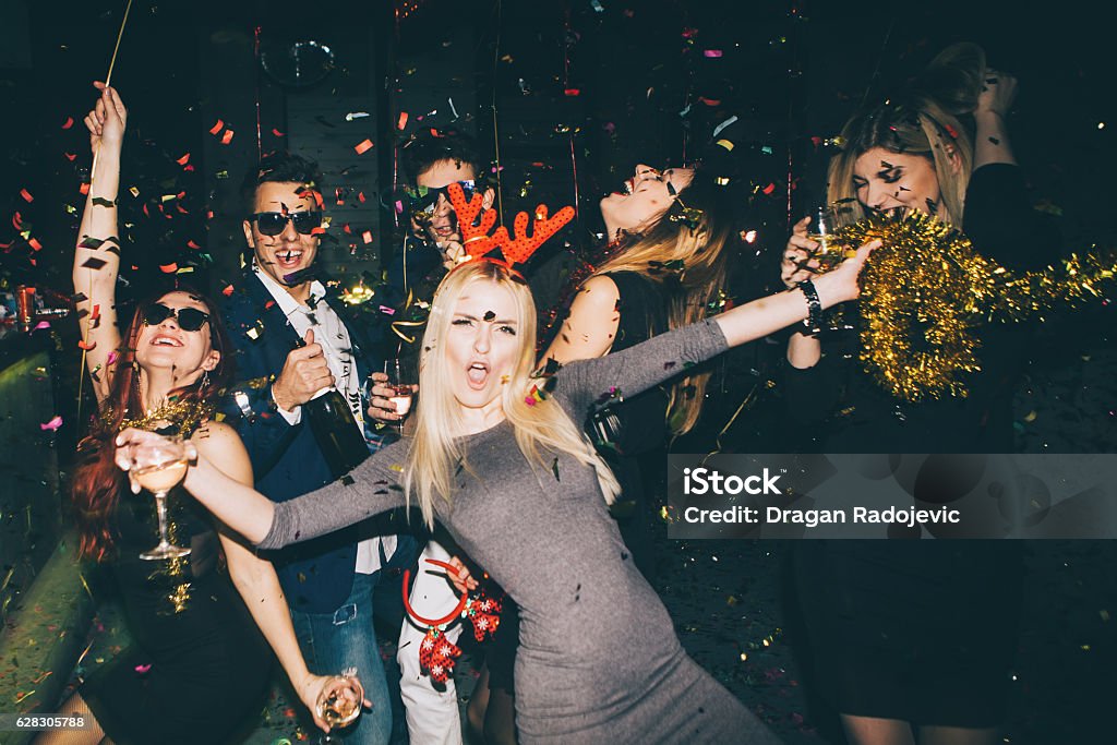 Group of friends having fun in the club Group of friends having fun for new year's eve in a club. Drinking and dancing together Party - Social Event Stock Photo