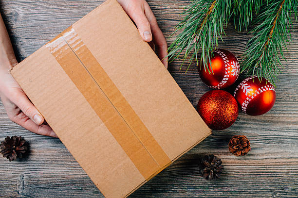 istock Girl holding a box over the table. Christmas background. 628308600
