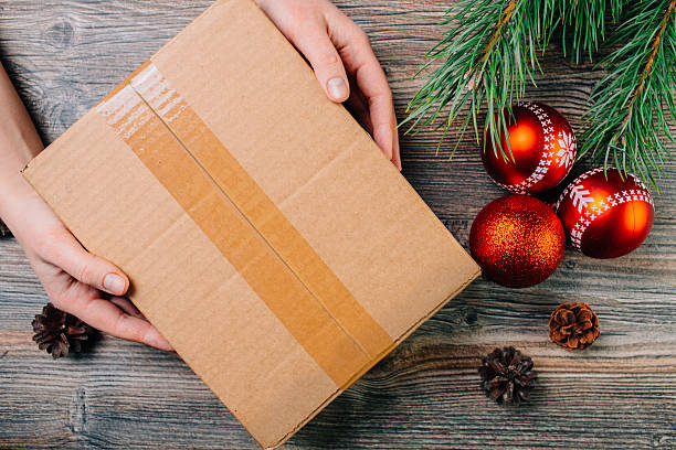 istock Girl holding a box over the table. Christmas background. 628308704