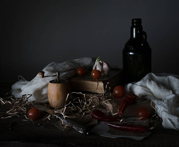 vintage. cherry tomatoes, old bottle with the oil mill and the old silver knife on a wooden table.