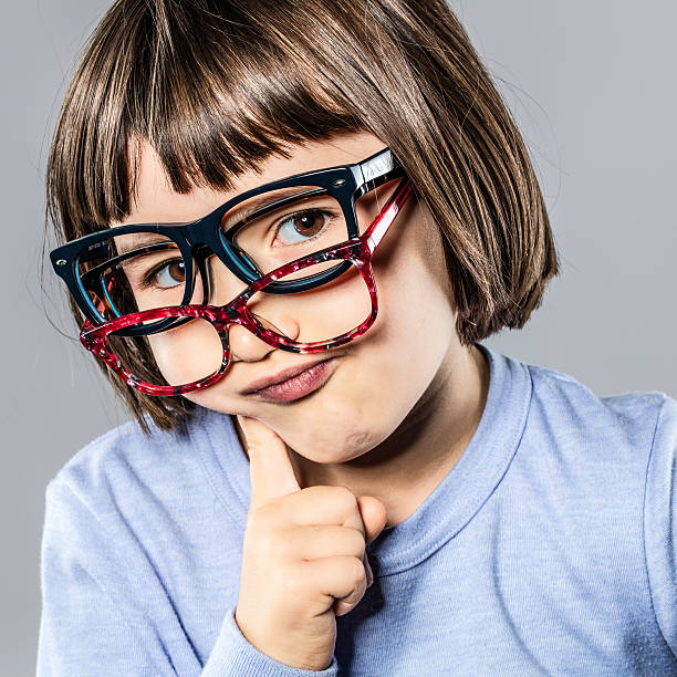 istock thinking cheeky little kid trying many eyeglasses hesitating for choice 628309242