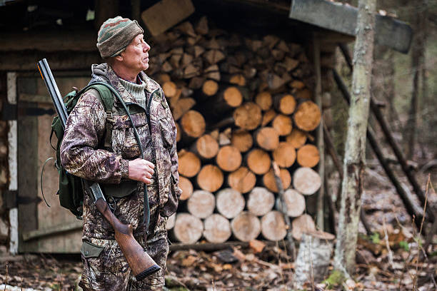 Male hunter in the forest Male hunter in the forest is about a hunting lodge woodland camo stock pictures, royalty-free photos & images