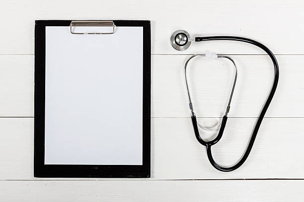 istock Medical clipboard and stethoscope on white wooden table 628318496